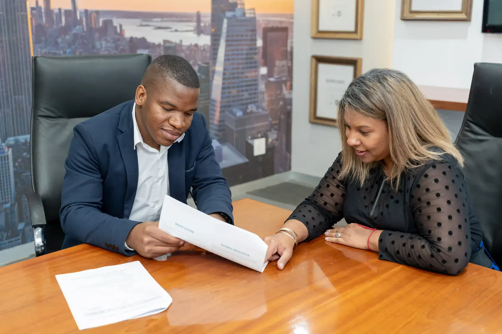 Two professionals reviewing documents in office meeting